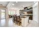 Bright kitchen features a center island with bar seating, dark cabinetry, and access to the outdoor living space at 3518 W Agate Ave, Las Vegas, NV 89139