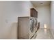 Spacious laundry room showcasing front loading washer and dryer, cabinetry for storage, and neutral tile flooring at 3518 W Agate Ave, Las Vegas, NV 89139