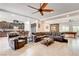 Expansive living room with modern kitchen view, cozy leather seating, and tiled flooring at 3518 W Agate Ave, Las Vegas, NV 89139