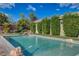 Backyard pool with unique rock features and lush privacy landscaping at 3518 W Agate Ave, Las Vegas, NV 89139