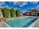 A sparkling pool surrounded by tall, manicured trees and a lush lawn at 3518 W Agate Ave, Las Vegas, NV 89139