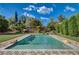 Lush backyard pool area with rock accents, landscaped garden, and brick patio at 3518 W Agate Ave, Las Vegas, NV 89139