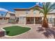 Spacious backyard with a covered patio, artificial turf, and mature palm trees at 3800 Crema Ct, Las Vegas, NV 89129