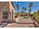 Large backyard featuring desert landscaping, a covered patio, and tall palm trees at 3800 Crema Ct, Las Vegas, NV 89129