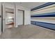 Bedroom with striped accent wall, closet, carpeted floor, and an open doorway to another room at 3800 Crema Ct, Las Vegas, NV 89129