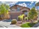 Inviting two-story home with arched entryway, two-car garage, and lush front yard landscaping at 3800 Crema Ct, Las Vegas, NV 89129