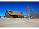 A charming log cabin featuring rustic appeal, complemented by a spacious lot and a clear blue sky at 3900 W Landberg Ave, Las Vegas, NV 89141