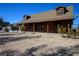 A rustic log cabin home with a porch, surrounded by desert landscaping and a wide-open space at 3900 W Landberg Ave, Las Vegas, NV 89141