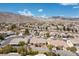 Neighborhood aerial view featuring many single Gathering homes and showing nearby desert mountains under a bright blue sky at 4416 Peaceful Morning Ln, Las Vegas, NV 89129