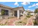 Charming backyard showcasing a covered patio, decorative rock, red brick pathway, and lush desert landscaping at 4416 Peaceful Morning Ln, Las Vegas, NV 89129