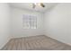A simple bedroom with a ceiling fan, carpeted floor, and bright lighting at 4416 Peaceful Morning Ln, Las Vegas, NV 89129