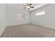 An airy bedroom with ceiling fan, carpeted floors, and sunlit windows at 4416 Peaceful Morning Ln, Las Vegas, NV 89129