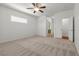 Bright bedroom features plush carpeting, ceiling fan, and attached bathroom at 4416 Peaceful Morning Ln, Las Vegas, NV 89129