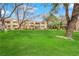 Community front yard features grass, mature trees, and a view of a residential building at 5170 S Jones Blvd # 205, Las Vegas, NV 89118