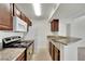 Kitchen featuring stainless steel oven, microwave, and granite countertop with wooden cabinetry at 5170 S Jones Blvd # 205, Las Vegas, NV 89118