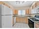 Functional kitchen featuring light wood cabinets, standard appliances, and a window over the sink at 5331 Heatherbrook Cir, Las Vegas, NV 89120
