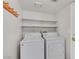 Functional laundry room with a washer, dryer, overhead shelves, and a coat rack at 5331 Heatherbrook Cir, Las Vegas, NV 89120