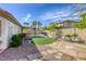 A spacious backyard with stone landscaping, artificial grass, an outdoor kitchen and a covered patio area at 5437 Escallonia St, Las Vegas, NV 89149
