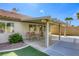 Backyard patio with covered seating, a small patch of grass, and lush, mature desert landscaping at 5437 Escallonia St, Las Vegas, NV 89149