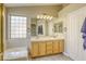 Bathroom featuring double sinks, large mirror, tile floors and a tub at 5437 Escallonia St, Las Vegas, NV 89149