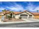 Exterior of home with a three-car garage, desert landscaping, and a tile roof at 5437 Escallonia St, Las Vegas, NV 89149