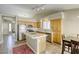 Well-lit kitchen with stainless appliances, tiled countertops, island, and breakfast bar seating area at 5437 Escallonia St, Las Vegas, NV 89149