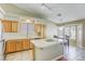 Charming kitchen with a vaulted ceiling, island with white tile countertop, and light wood cabinetry at 5437 Escallonia St, Las Vegas, NV 89149