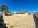 Backyard with desert landscaping, mature tree, and a small patio area at 6397 Kell Ln, Las Vegas, NV 89156