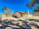 An exterior shot of the backyard and the rear of the property shows some desert landscaping at 6397 Kell Ln, Las Vegas, NV 89156
