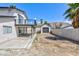 Wide backyard view features a two-story home with balcony, separate garage, and desert landscape at 6401 Goldmine Dr, Las Vegas, NV 89156