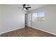 Bedroom with wood-look floors, ceiling fan, and window overlooking the neighborhood at 6401 Goldmine Dr, Las Vegas, NV 89156