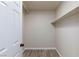 A walk-in closet with neutral walls, wood-look floors and built-in shelving at 6401 Goldmine Dr, Las Vegas, NV 89156