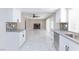 Open kitchen view with white cabinets, granite counters, and view of the living room at 6401 Goldmine Dr, Las Vegas, NV 89156