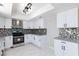 Well-lit kitchen with white cabinetry, modern range hood, and tile flooring at 6401 Goldmine Dr, Las Vegas, NV 89156