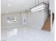 Bright living room featuring tile floors, staircase, and modern lighting at 6401 Goldmine Dr, Las Vegas, NV 89156