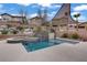 Relaxing pool and spa with custom waterfall feature, large tanning ledge, shade sail, and surrounding desert landscaping at 651 Penshaw Bridge Ave, Las Vegas, NV 89178