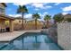 Beautiful pool and spa area with elegant tile, waterfall feature, landscaping, and ample patio space for outdoor entertaining at 651 Penshaw Bridge Ave, Las Vegas, NV 89178