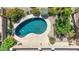 Aerial view of a kidney shaped pool, surrounded by desert landscaping and a beige patio at 6917 Puetollano Dr, North Las Vegas, NV 89084