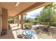 Covered back patio features a dining table set and serene views of desert landscaping and the pool at 6917 Puetollano Dr, North Las Vegas, NV 89084