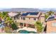 Aerial view of a backyard featuring a refreshing pool, patio area, palm trees, and solar panels on the roof at 6917 Puetollano Dr, North Las Vegas, NV 89084