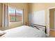 Bright bedroom with large window, closet, and neutral color palette offers comfortable living at 6917 Puetollano Dr, North Las Vegas, NV 89084