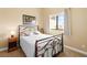 Cozy bedroom featuring a wrought iron bed frame and a large window with natural light at 6917 Puetollano Dr, North Las Vegas, NV 89084