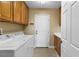 Functional laundry room with modern appliances, storage cabinets, and convenient sink at 6917 Puetollano Dr, North Las Vegas, NV 89084