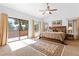 Bright main bedroom featuring a ceiling fan, neutral walls, and sliding glass doors leading to a balcony at 6917 Puetollano Dr, North Las Vegas, NV 89084