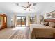 Spacious main bedroom featuring a ceiling fan, neutral walls, and sliding glass doors leading to a balcony at 6917 Puetollano Dr, North Las Vegas, NV 89084