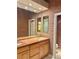 Modern bathroom with long countertop, dual sinks, and textured wallpaper at 6987 Emerald Springs Ln, Las Vegas, NV 89113