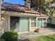 Cozy patio with a tile roof, sliding door, and beautiful greenery, offering a tranquil outdoor space at 6987 Emerald Springs Ln, Las Vegas, NV 89113