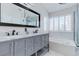 A bathroom with double sink vanity, marble countertops, and soaking tub with window shutters at 7905 Coral Point Ave, Las Vegas, NV 89128