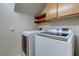Functional laundry area with a side-by-side washer and dryer and upper cabinets for storage at 7905 Coral Point Ave, Las Vegas, NV 89128