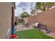 Landscaped backyard with patio, seating, green turf, and playground equipment for recreation at 7919 Mineral Peak St, Las Vegas, NV 89166